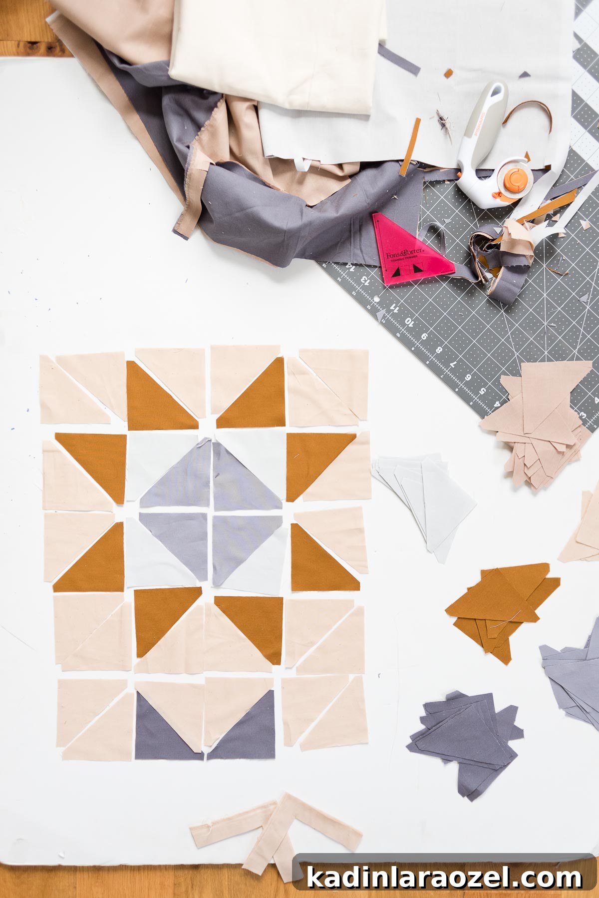 Cutting quilting triangles out of fabric into a pattern.