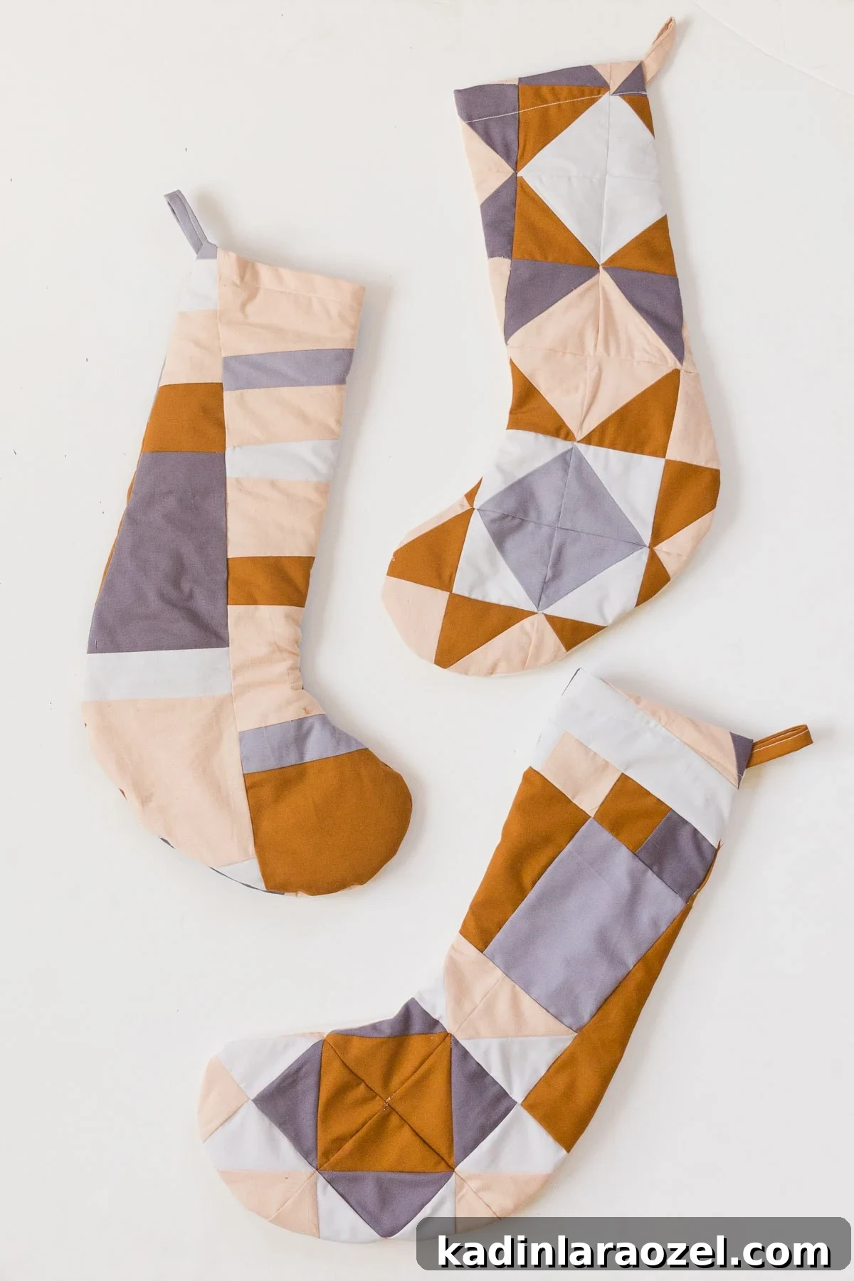 Earth-toned Christmas stockings in various quilted patterns.