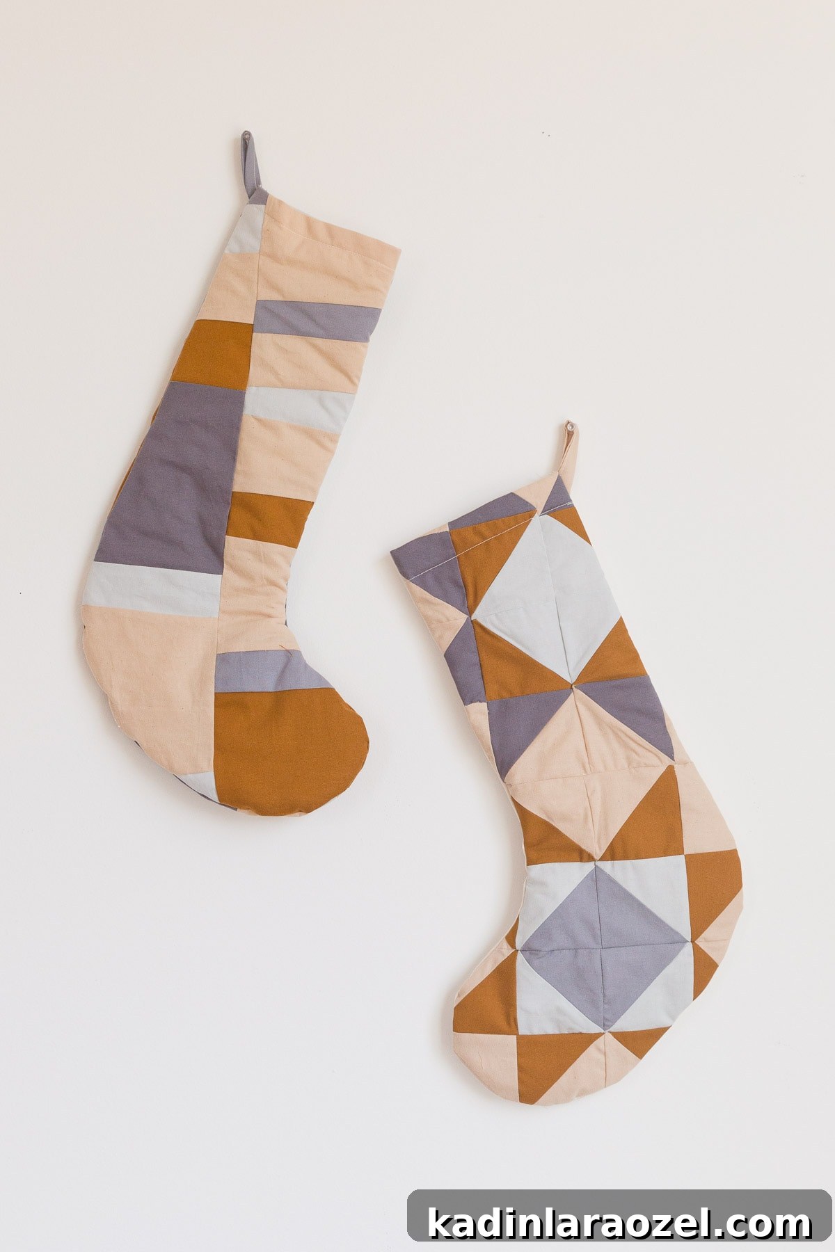 Quilted Christmas stockings in neutral, earthy colors.