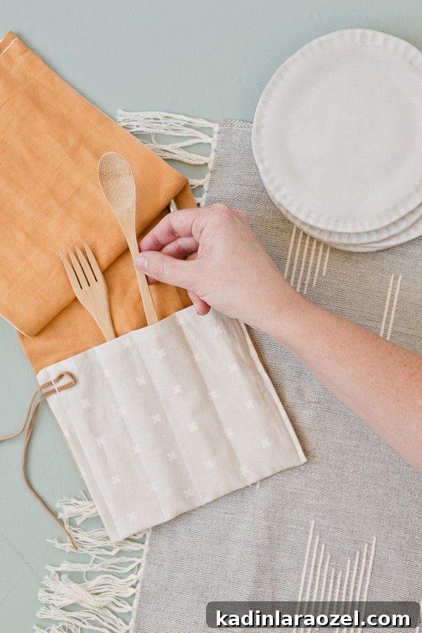 Hand reaching into frame to grab wooden utensil from DIY fabric utensil wrap.