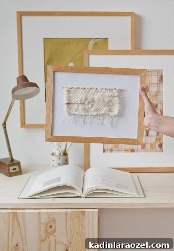 Mini weaving framed and held up in front of other artwork
