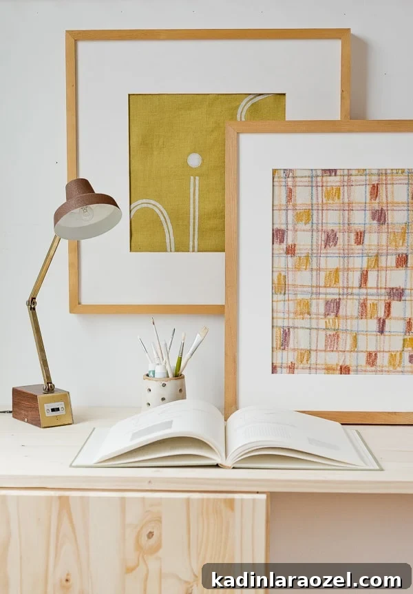 Mustard yellow abstract artwork and modern, linear artwork leaning against wall in office
