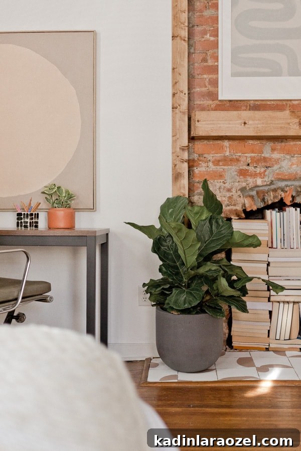 Bedroom with old brick fireplace and big bushy plant next to desk workspace
