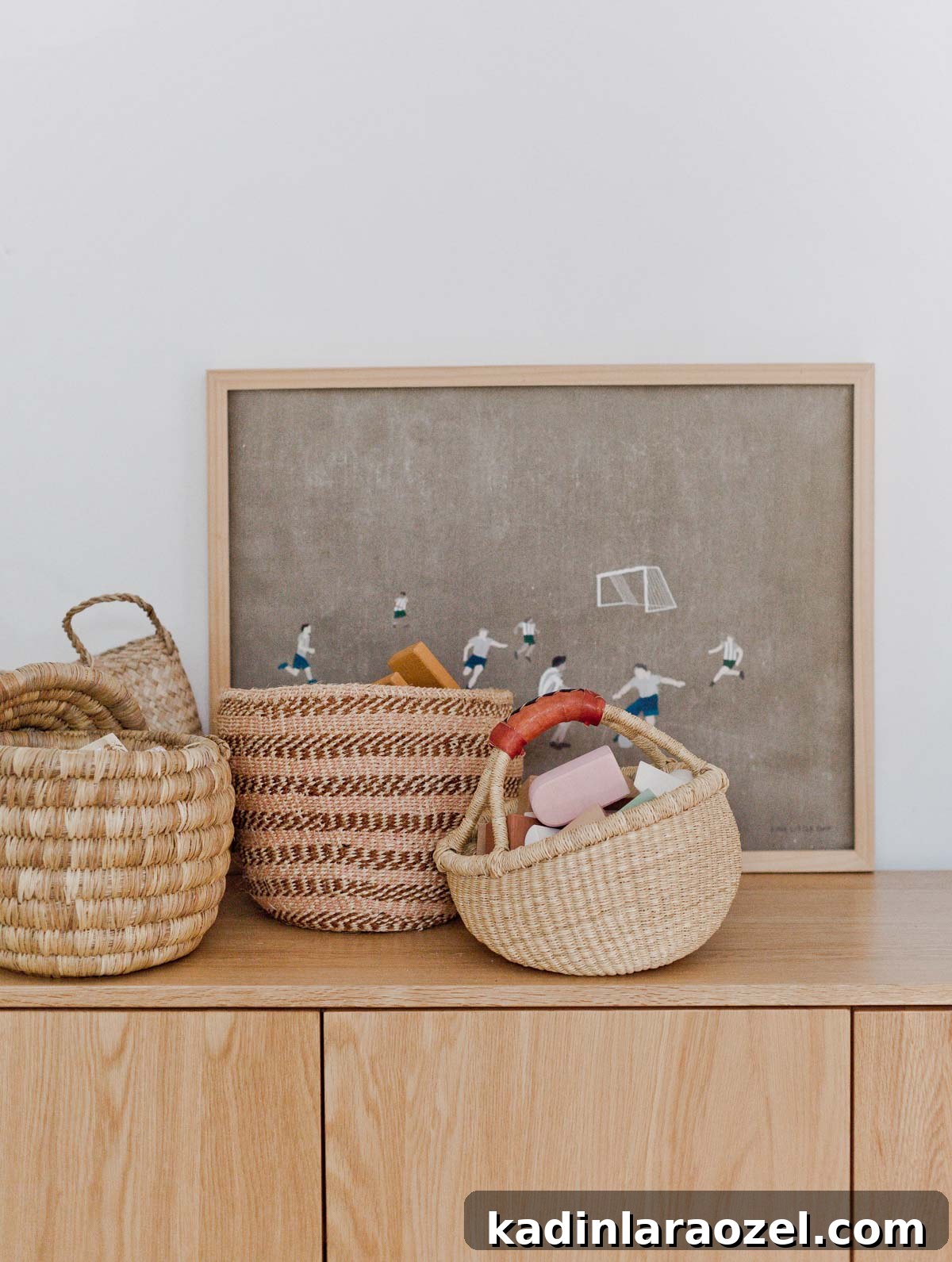 Decorate Your Home for Free: Creative Low-Cost Styling Ideas 14 woven baskets filled with wooden toys, sitting on a wood dresser with artwork behind it