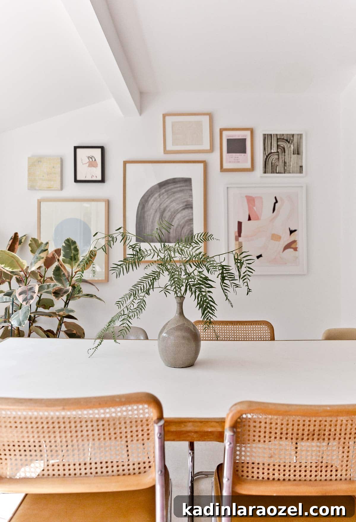 Decorate Your Home for Free: Creative Low-Cost Styling Ideas 3 large gallery wall of abstract artwork over a dining room table with plants