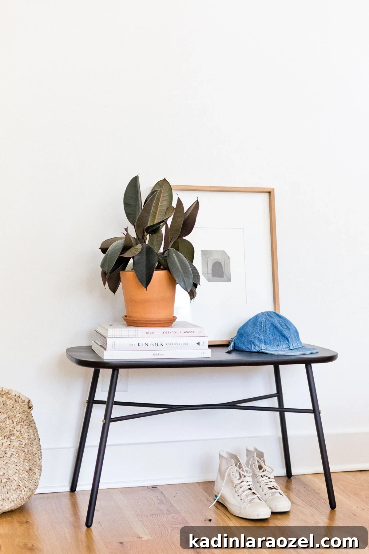 Decorate Your Home for Free: Creative Low-Cost Styling Ideas 6 modern black bench with books, plants and abstract artwork resting on top, with white sneakers underneath