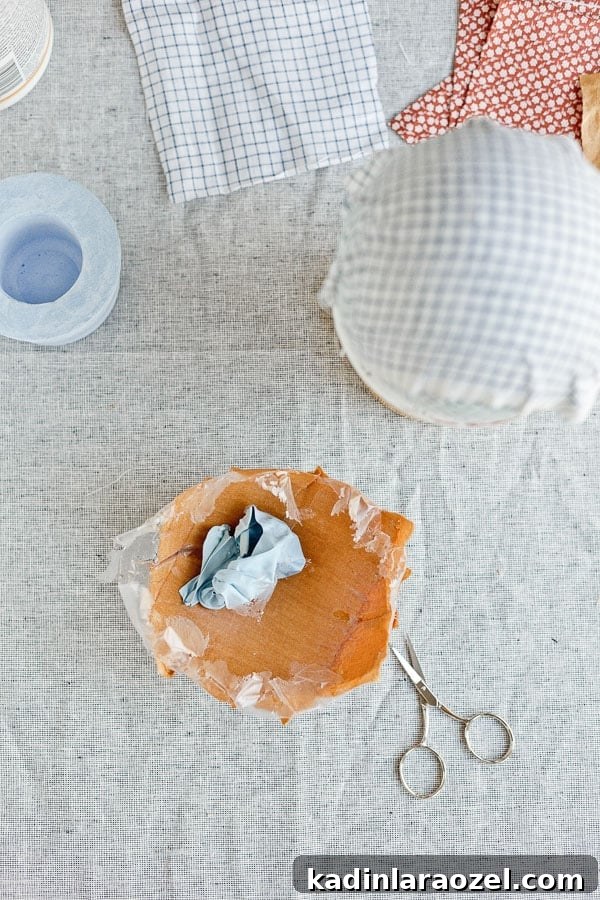 Deflated balloon being removed from a DIY fabric bowl in burnt orange color.