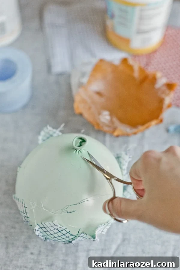 Popping balloon with scissors for paper mâché fabric project
