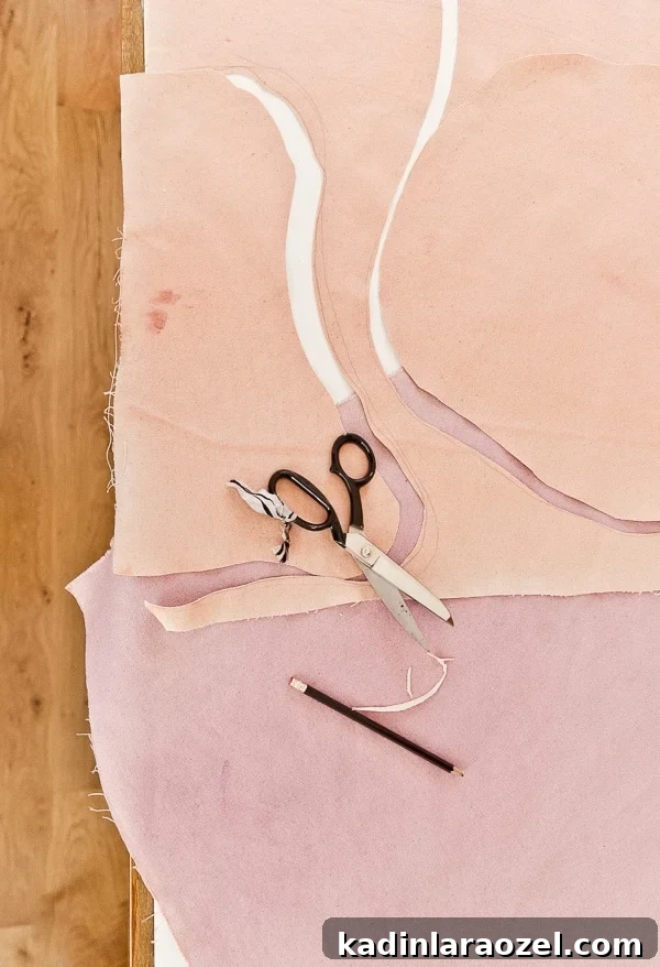 Cutting abstract shapes with scissors from large pieces of painted canvas.