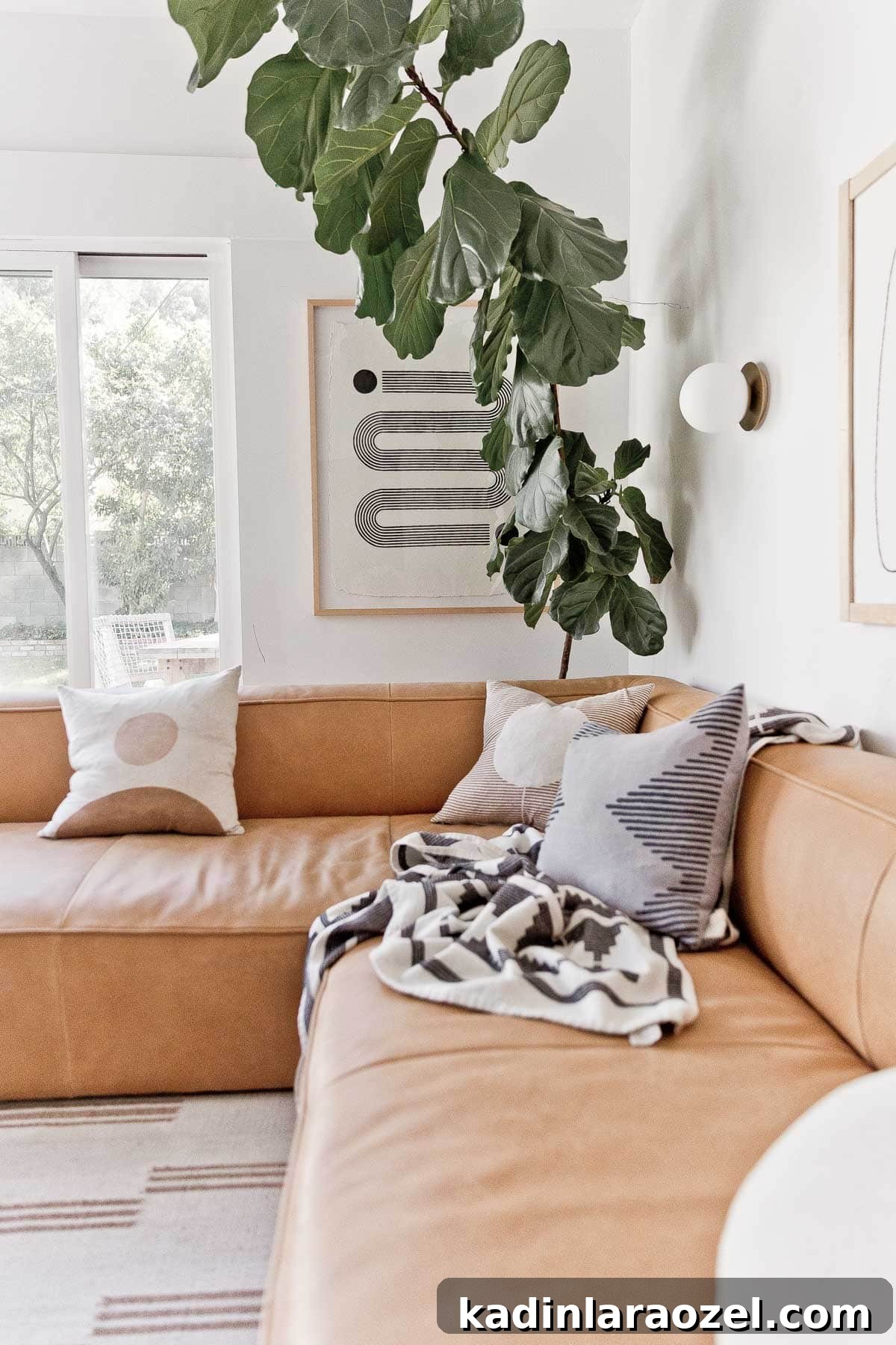 Where to Buy Art: Top Places to Find Original Artwork 4 Black and white, modern abstract artwork hanging in a living room with a large fiddle leaf fig tree.