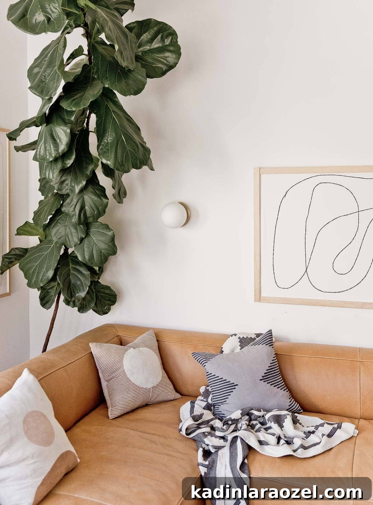 Lounge Room Makeover: In-Depth Furniture Review and Guide 3 Image of Article leather sectional with giant fiddle leaf fig in the background.