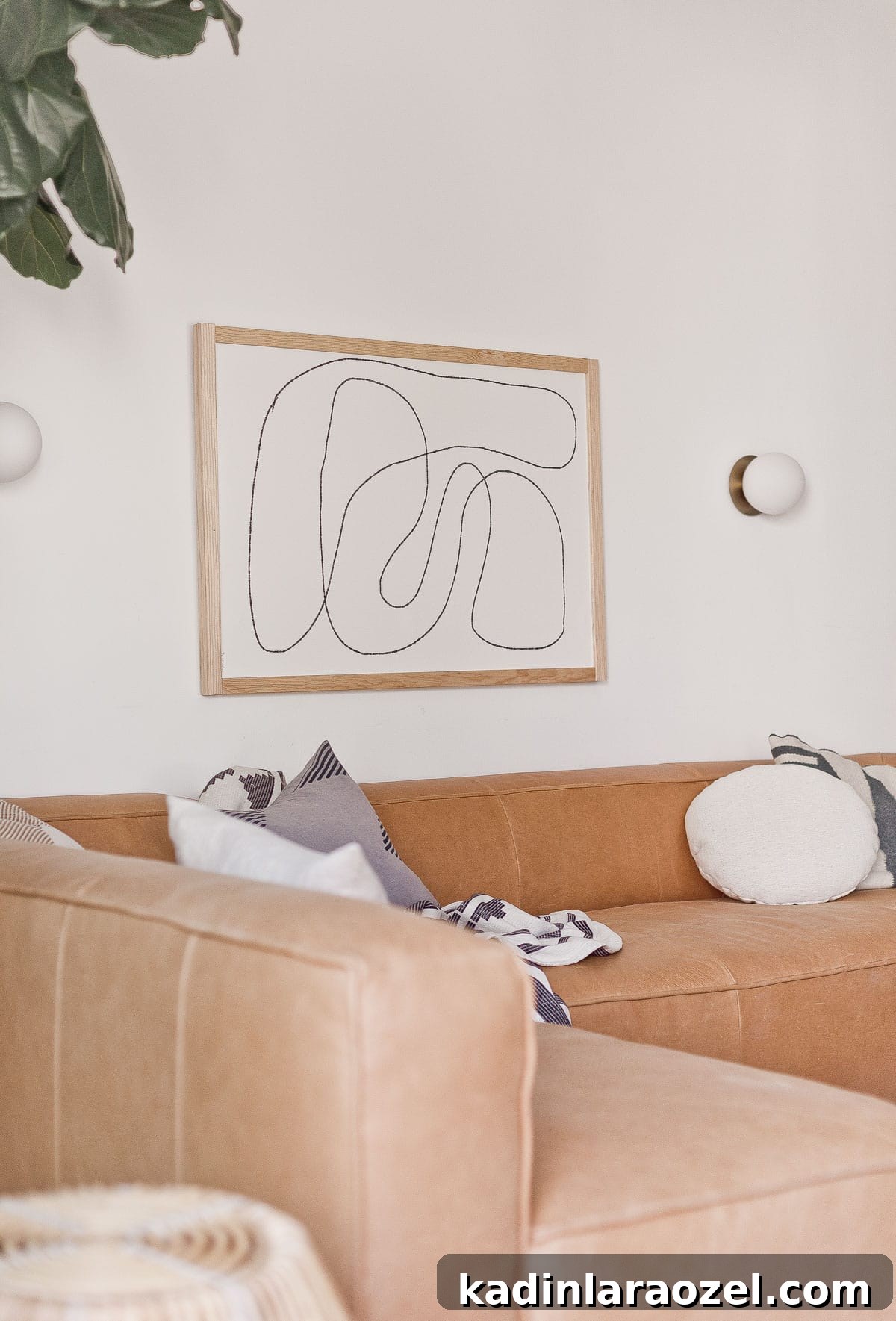 Lounge Room Makeover: In-Depth Furniture Review and Guide 8 Photo of leather sectional from Article with neutral pillows and abstract artwork.
