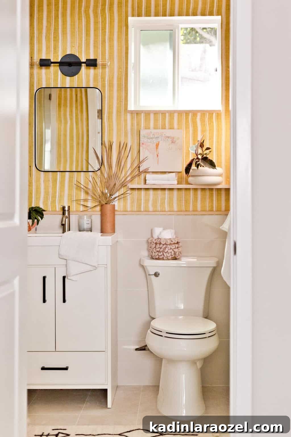 Yellow Bathroom Reveal: Stylish Renter-Friendly Makeover 5 Yellow striped bathroom with white vanity and black, modern accents.