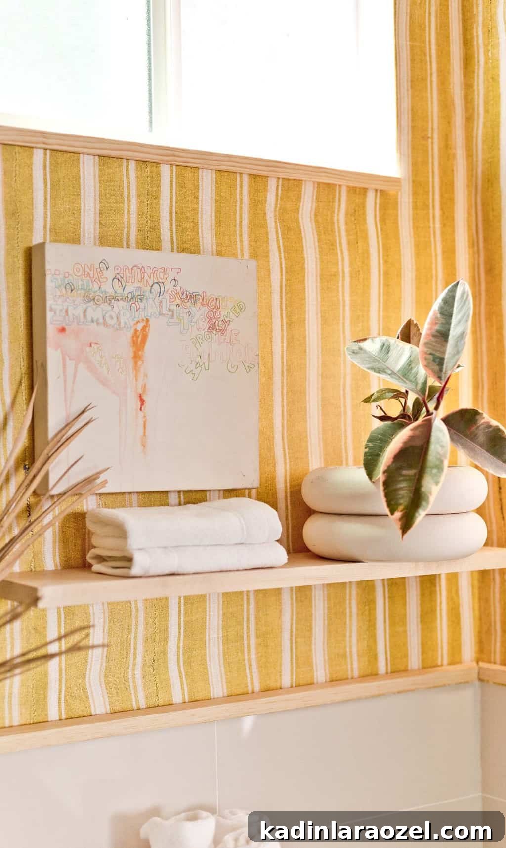 Yellow Bathroom Reveal: Stylish Renter-Friendly Makeover 9 Wood floating shelf holding plants and artwork on a bold, striped background.
