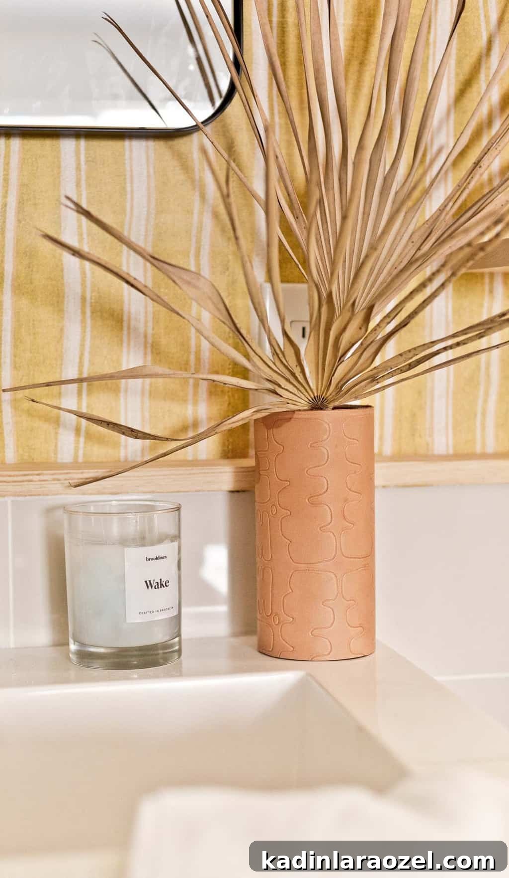 Yellow Bathroom Reveal: Stylish Renter-Friendly Makeover 10 Embossed leather vase with funky pattern in a striped, colorful bathroom.