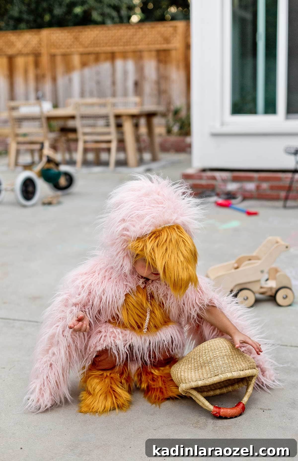 Child wearing handmade bird costume, playing in the backyard.