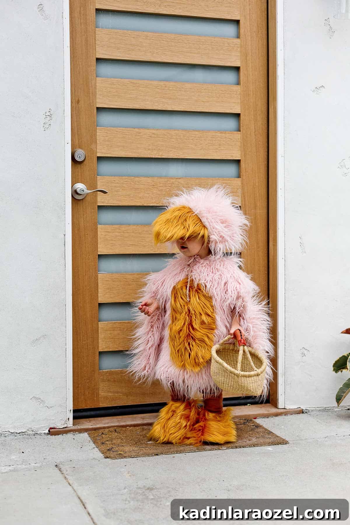 Child wearing a DIY Halloween costume of pink and yellow furry bird.