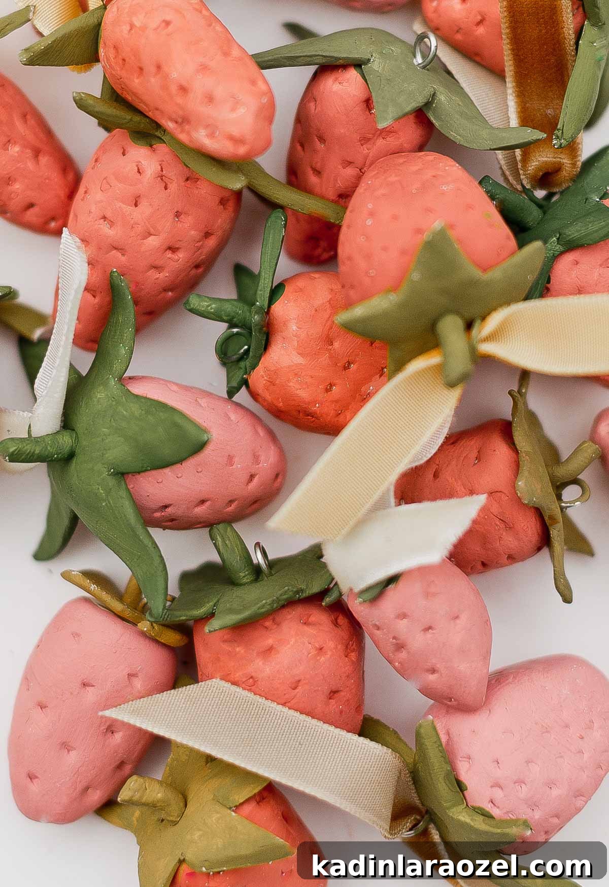 Closeup of clay strawberries in various reds and pinks.