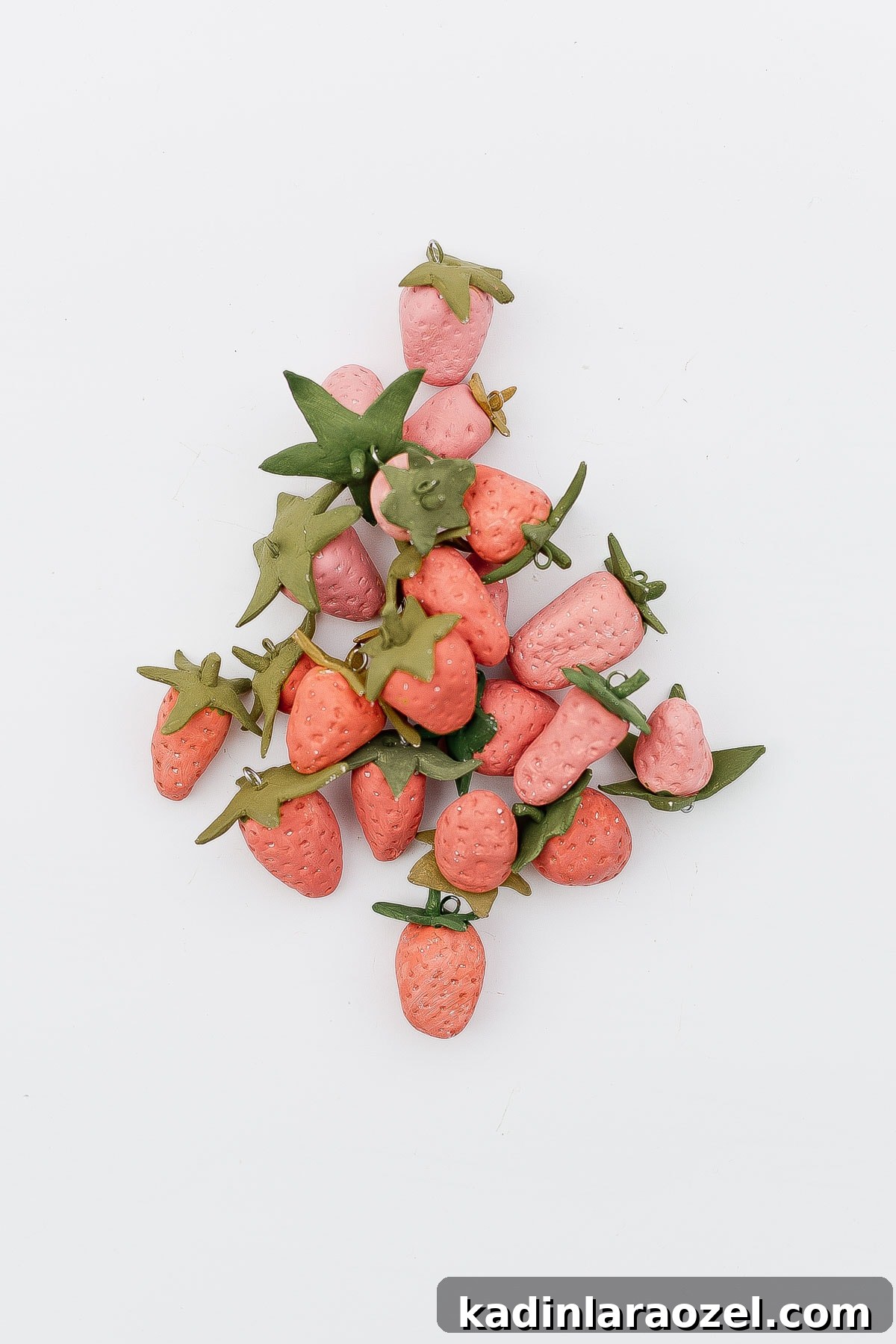 Clay strawberries in a pile shaped like a Christmas tree.