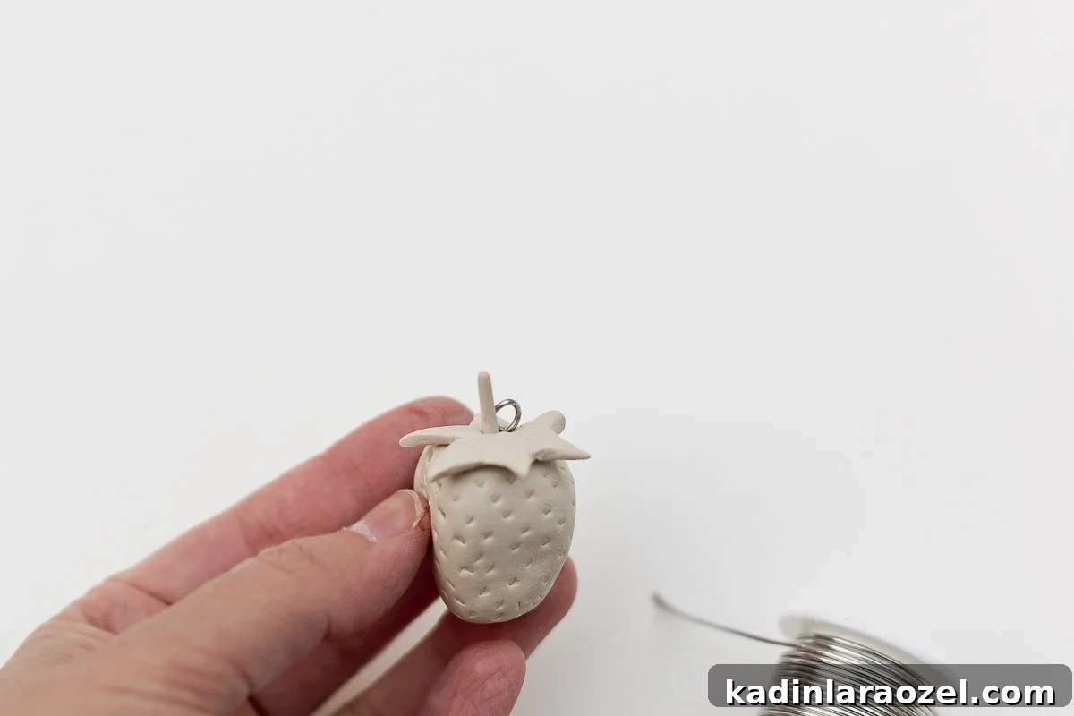 Air dry clay strawberry with wire loop for hanging.