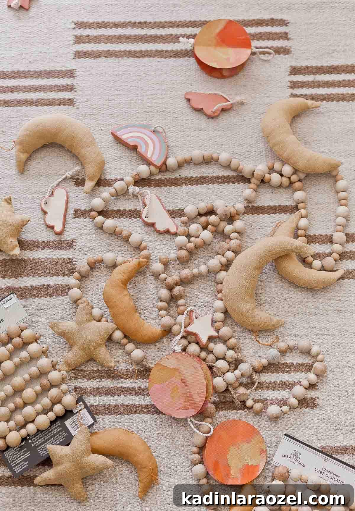 Handmade moon and star ornaments and wood beaded garland on a striped rug.