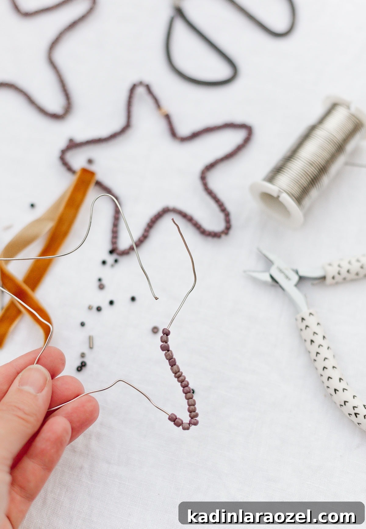 DIY Beaded Christmas Ornaments: Step-by-Step Holiday Craft Guide 5 Holding star wire with beads added on.