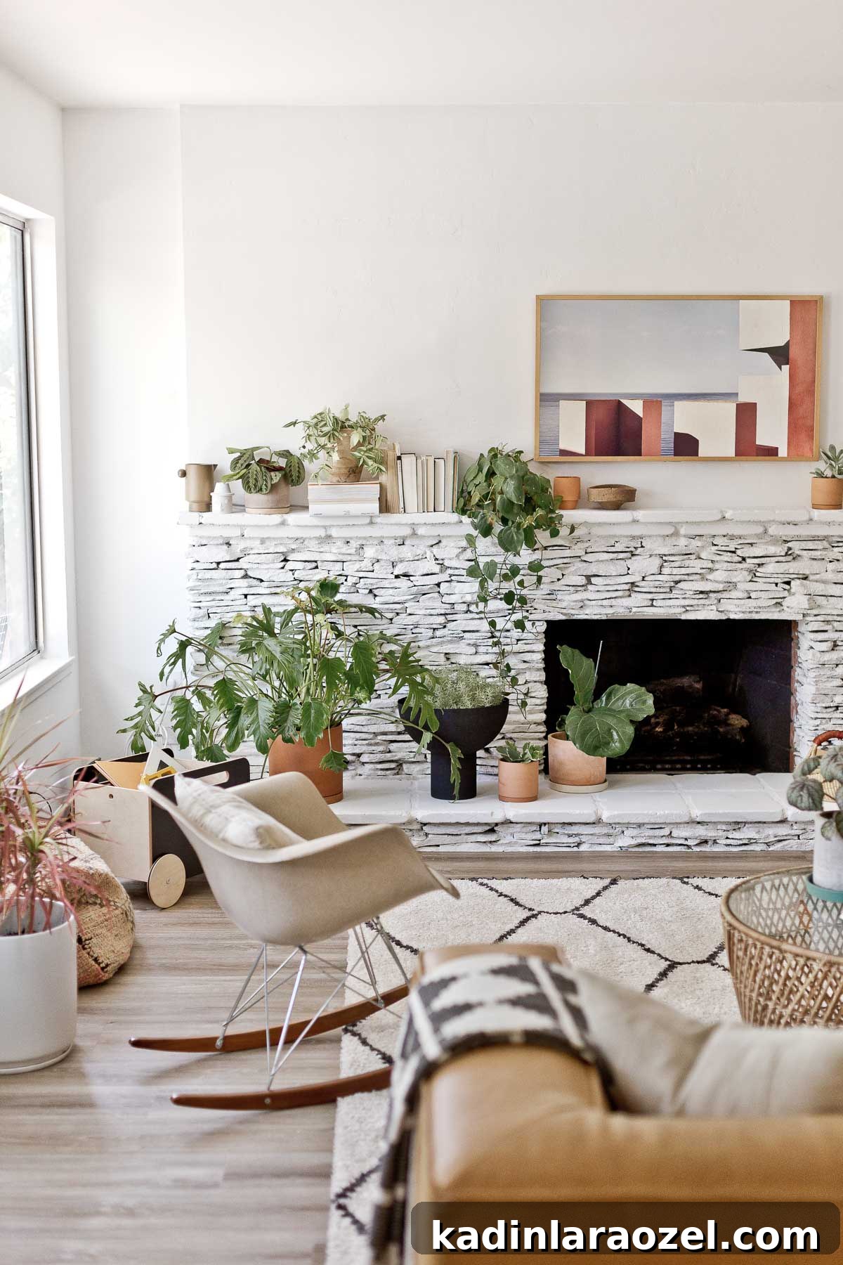 Fireplace Makeover Before & After: Stunning Transformations and Ideas 12 white painted fireplace made of stone with modern rocking chair and large plants throughout the room