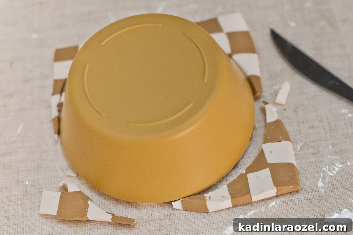 Cutting clay slab away from bowl shape to create circle.