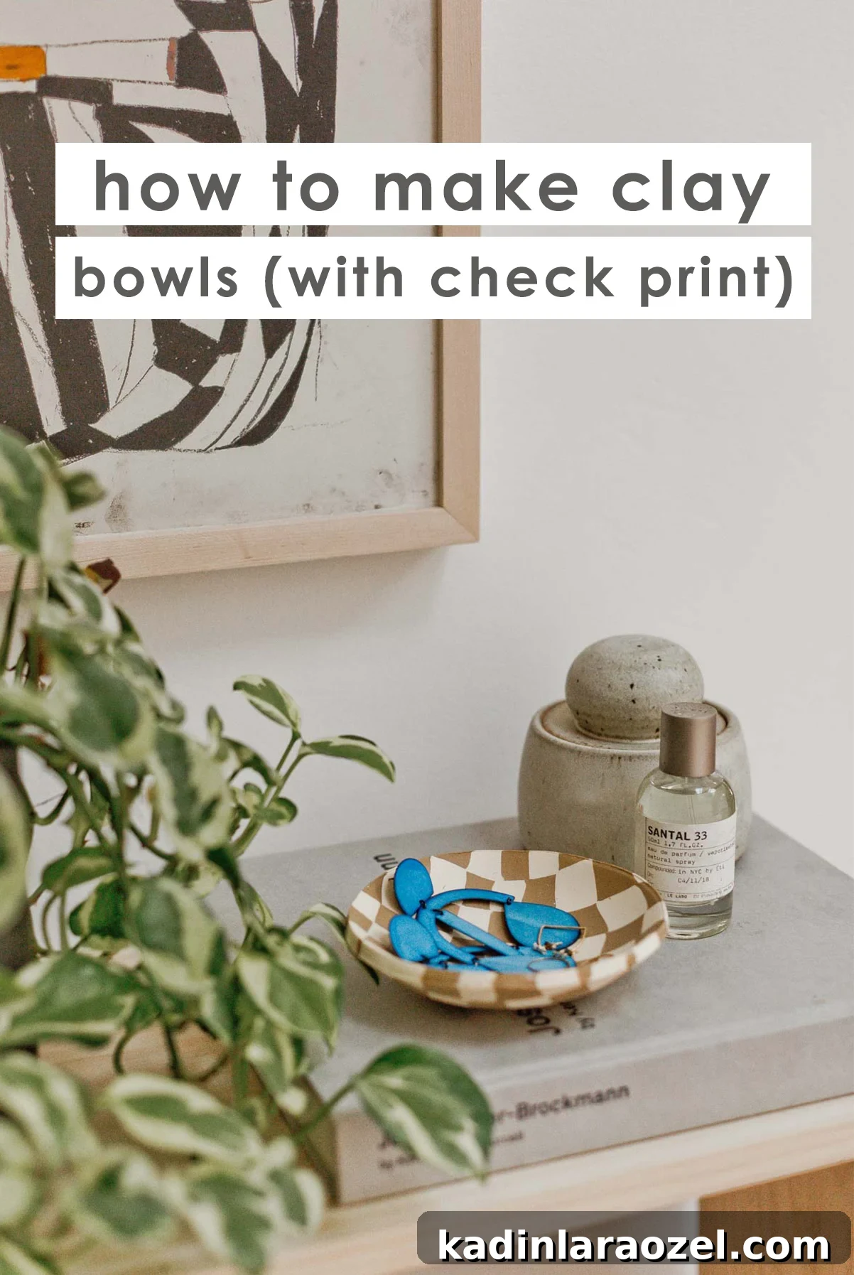 Check print clay bowl resting on book on top of modern table.