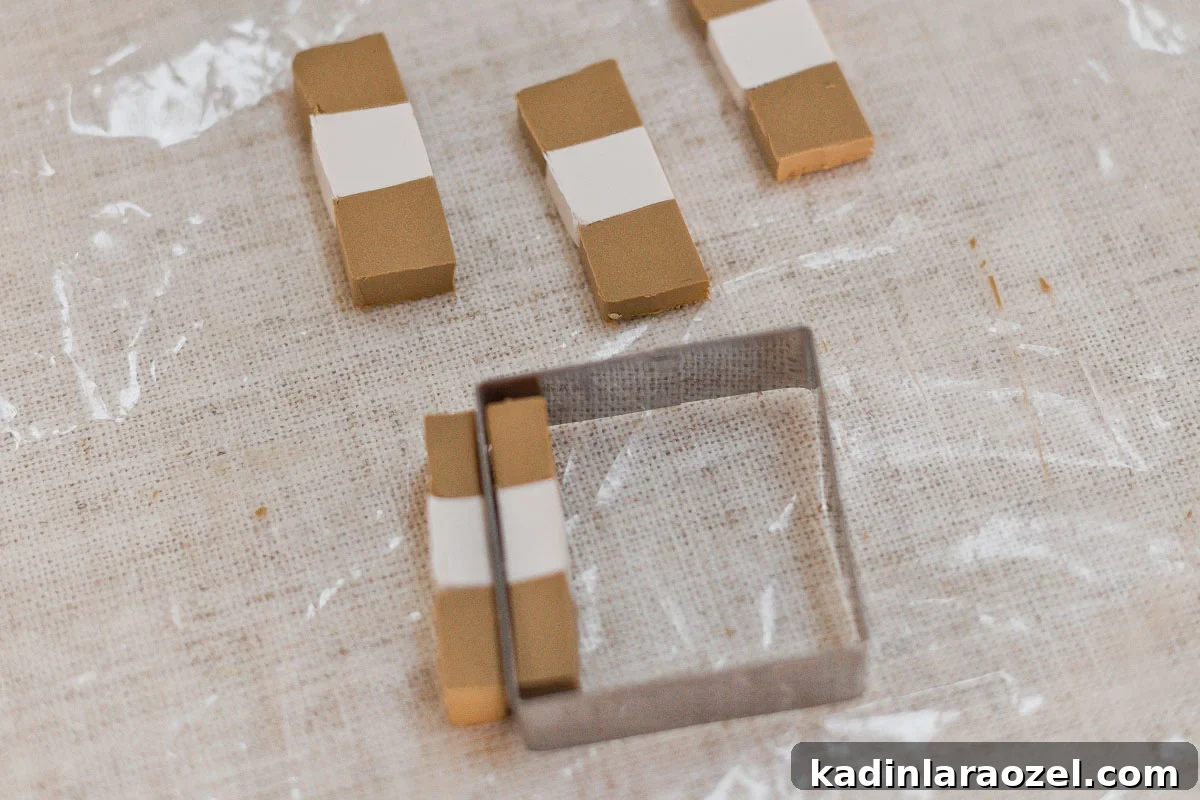 Cutting clay into squares with cookie cutter.