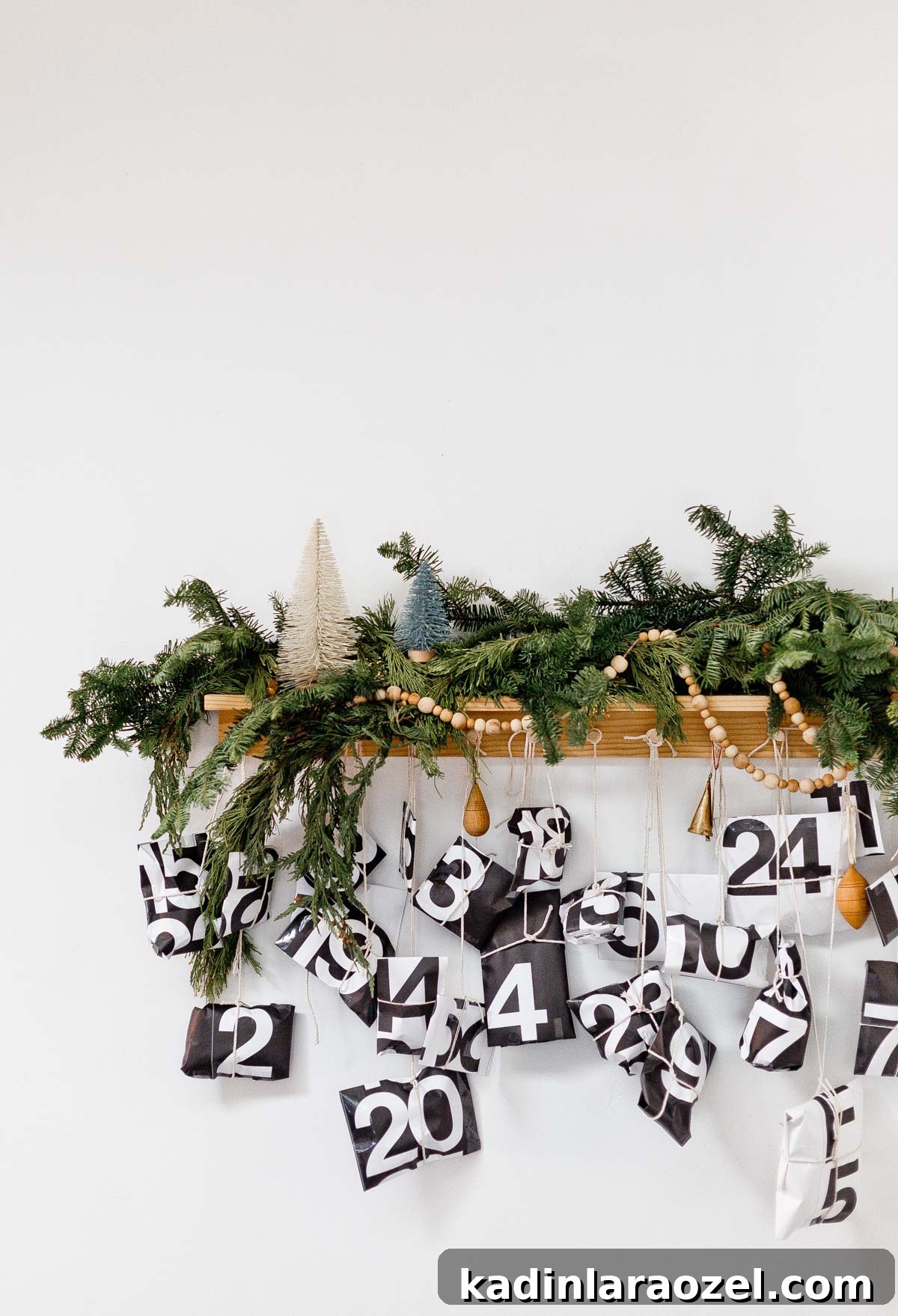 50 Advent Calendar Ideas to Delight Every Day in December 3 Modern advent calendar hanging from peg rail with Christmas garland