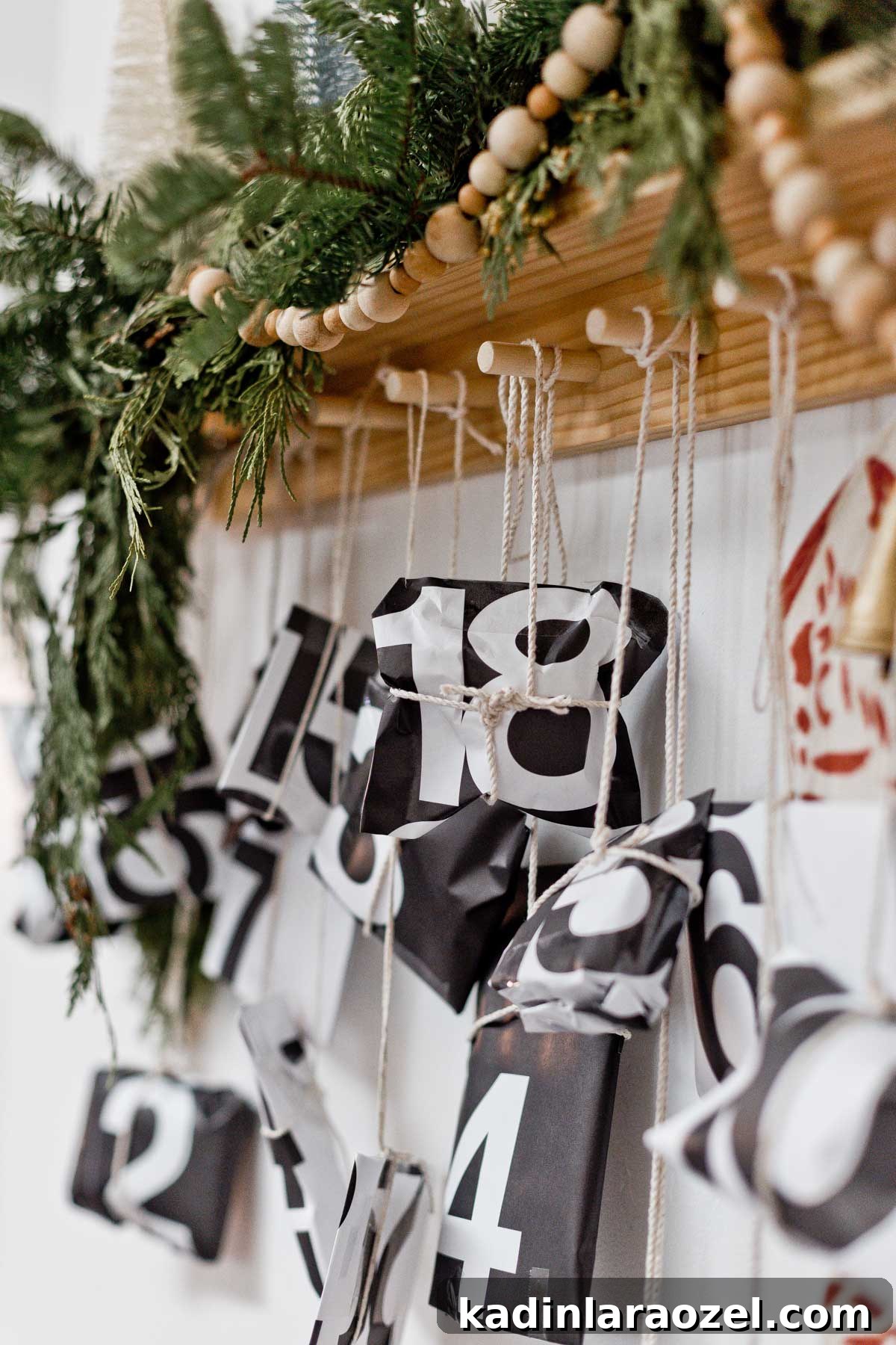 50 Advent Calendar Ideas to Delight Every Day in December 8 Black and white packages tied with string, hanging from peg rail with garland