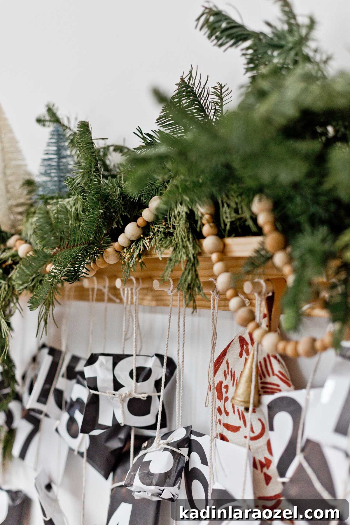 50 Advent Calendar Ideas to Delight Every Day in December 10 Tied paper packages hanging from modern peg rail with garland