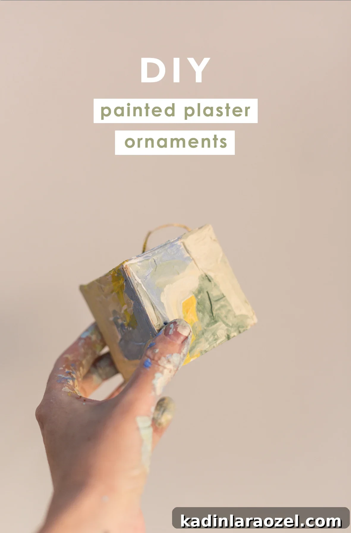 Painted textured ornament shaped like a square being held in hand