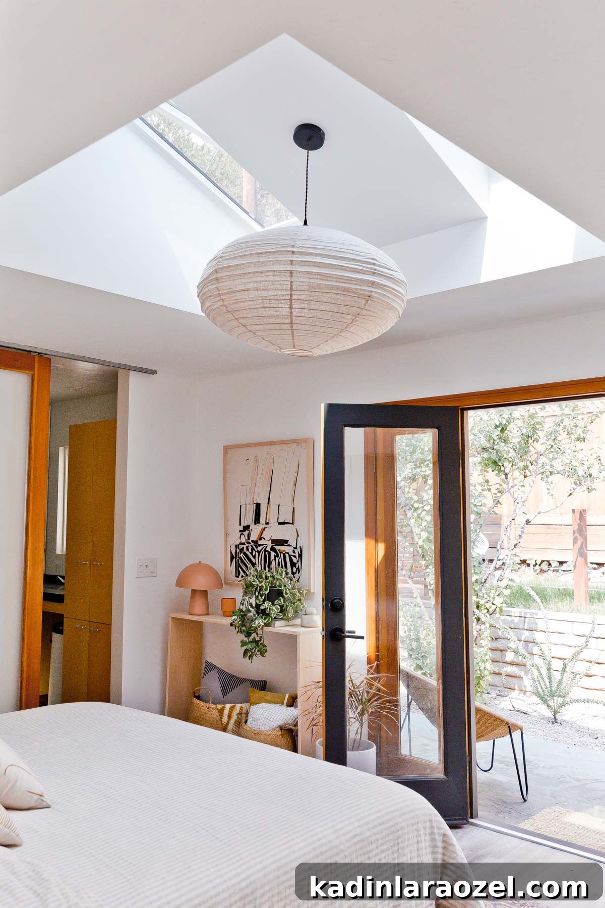 Primary bedroom with simple console table and paper lantern pendant