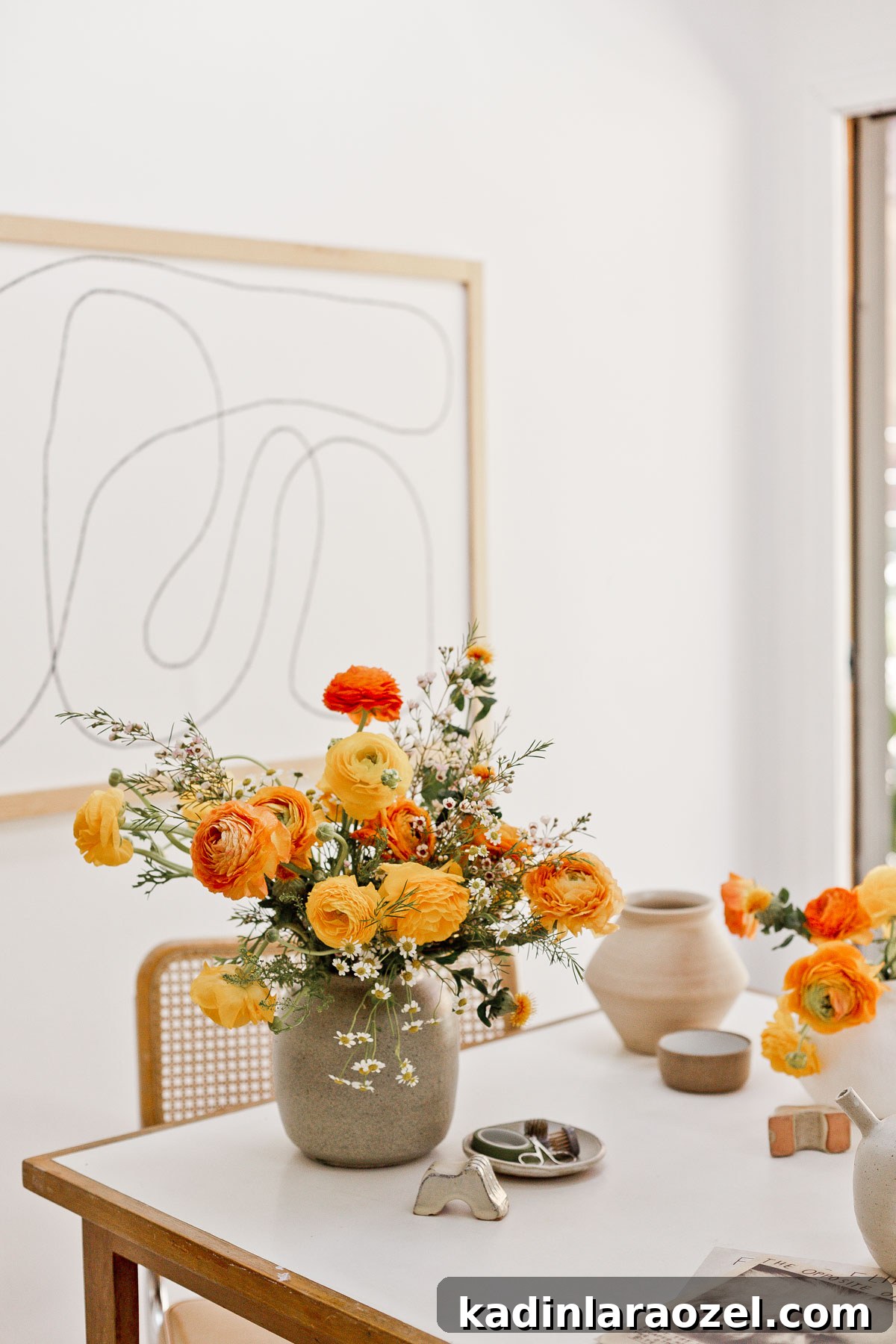 7 Pro Flower Arrangement Tips for Stunning Home Displays 12 Yellow and orange ranunculus centerpiece resting on white dining room table