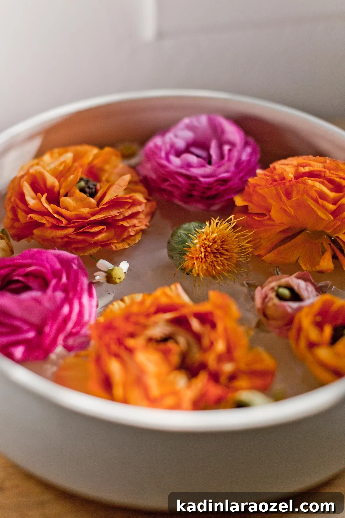 7 Pro Flower Arrangement Tips for Stunning Home Displays 7 Pink and orange ranunculus floating in white ceramic bowl with water