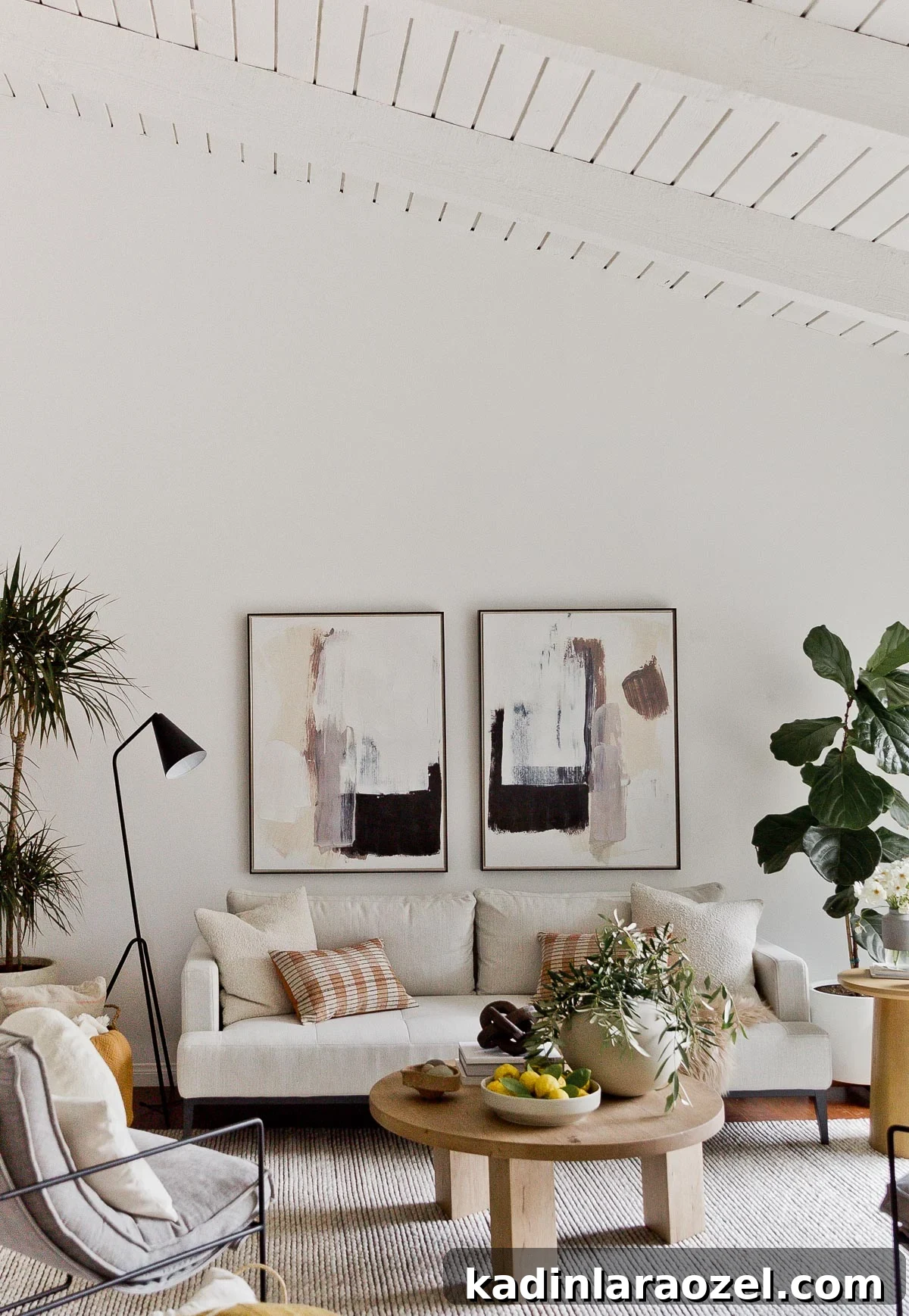 Neutral earthy living room with ivory furniture, abstract artwork, and lots of plants