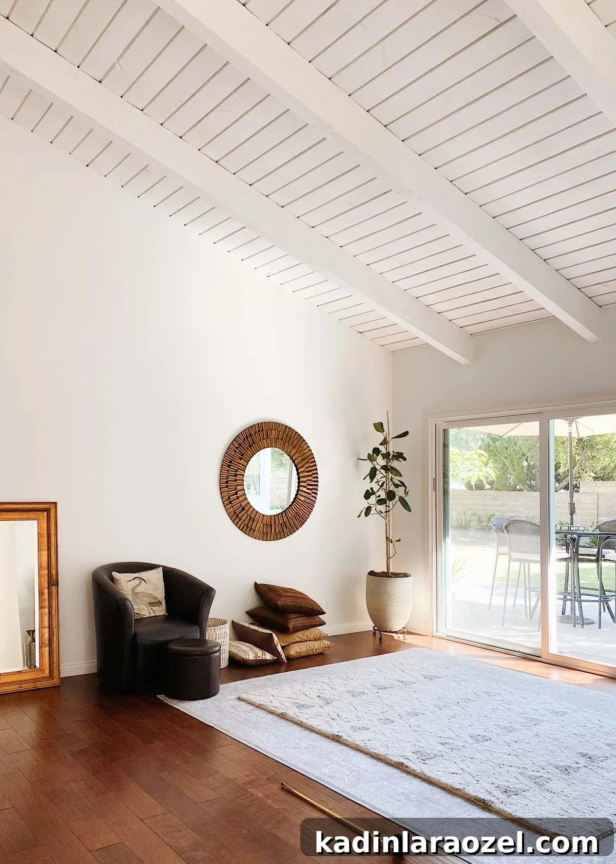White living room with minimal furniture - high ceilings and dark hardwood floors