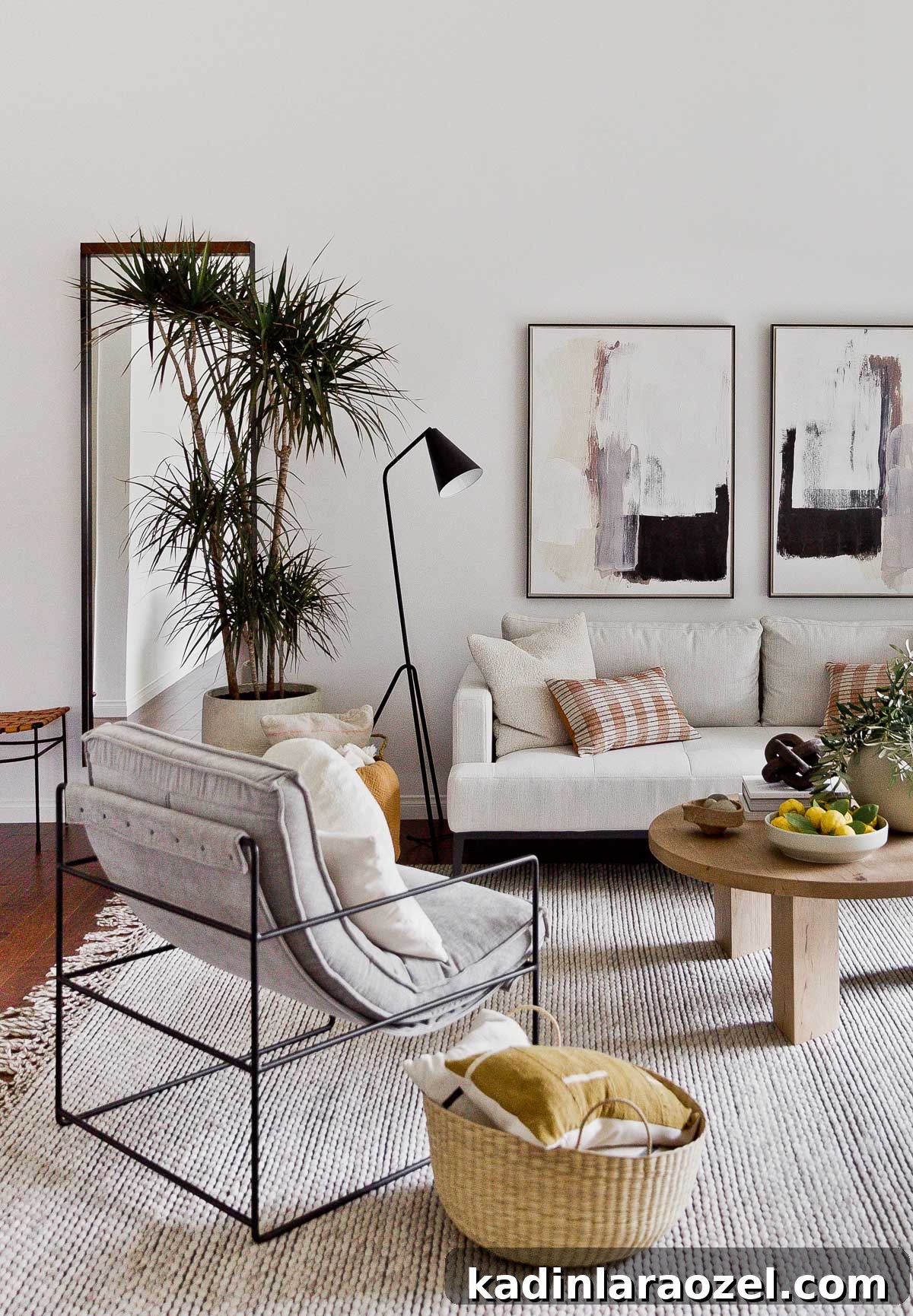Living room with modern light grey chair and white sofa with black accents and plants