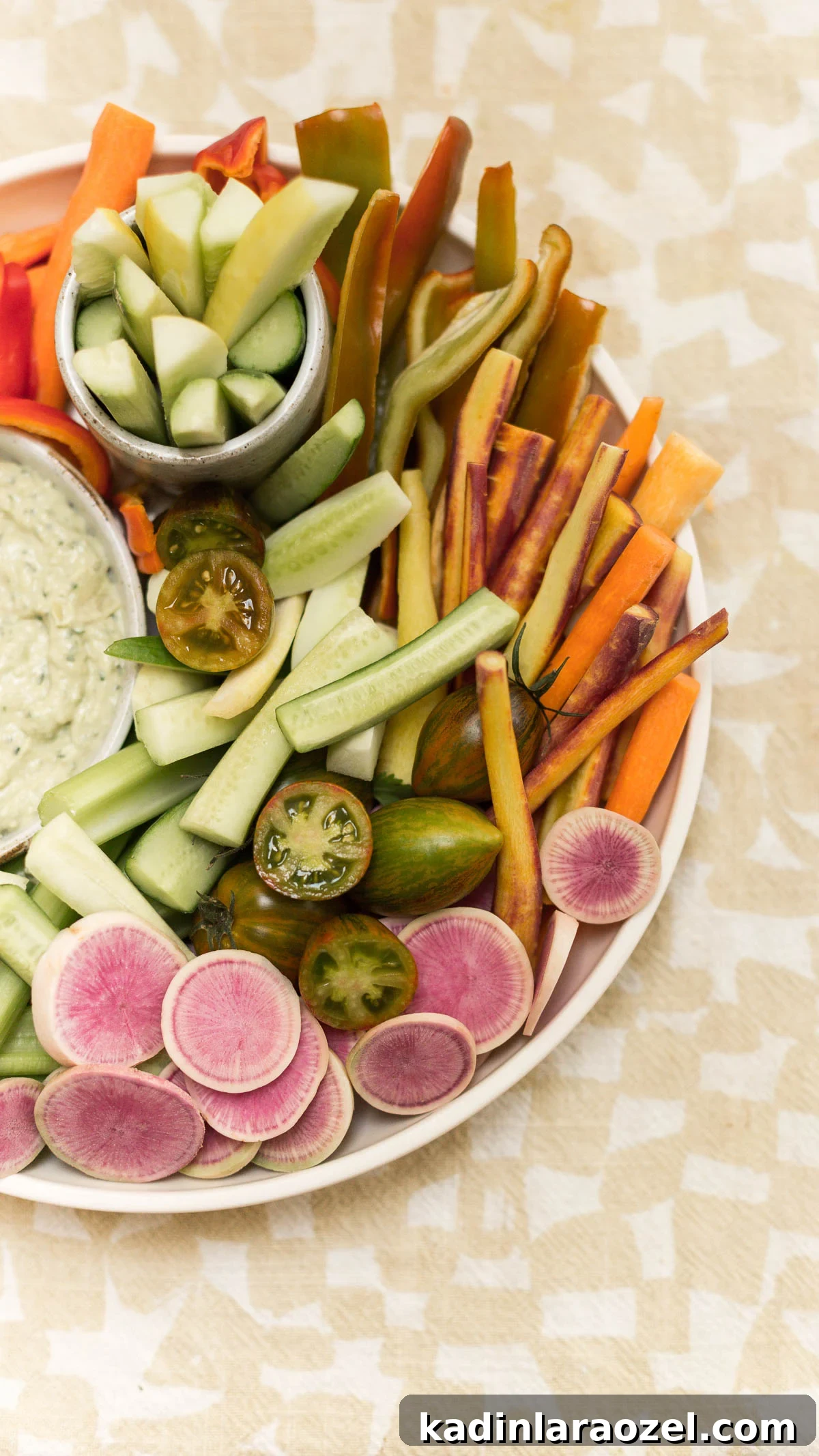 Fresh farmers market veggies on display on large platter with hummus.