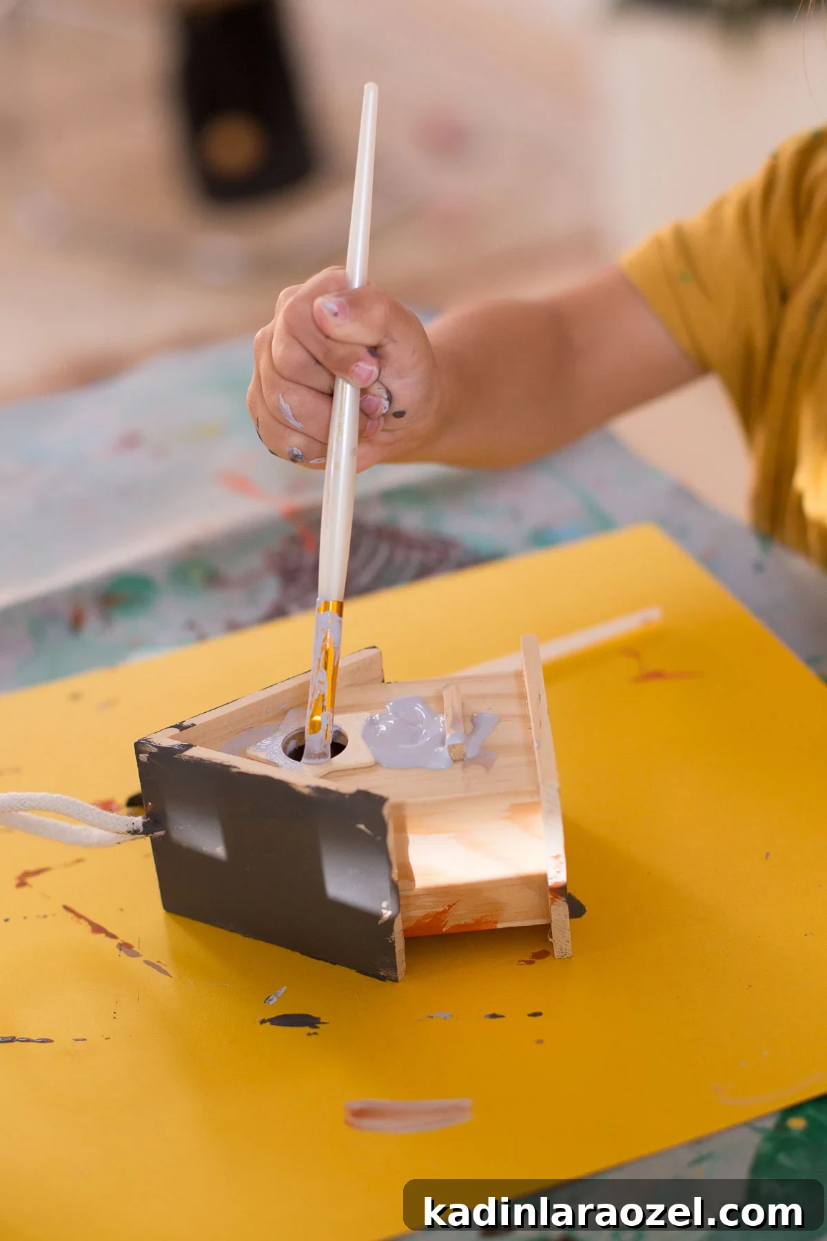 Birdhouse Craft Kits for Kids Party Favors 3 Child painting birdhouse on table, with small paintbrush.