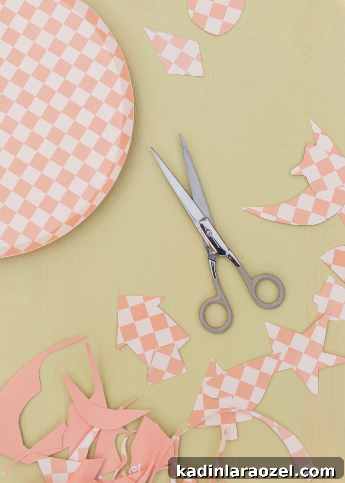 scissors and checkered paper plates being cut into different shapes to use an ornaments for christmas