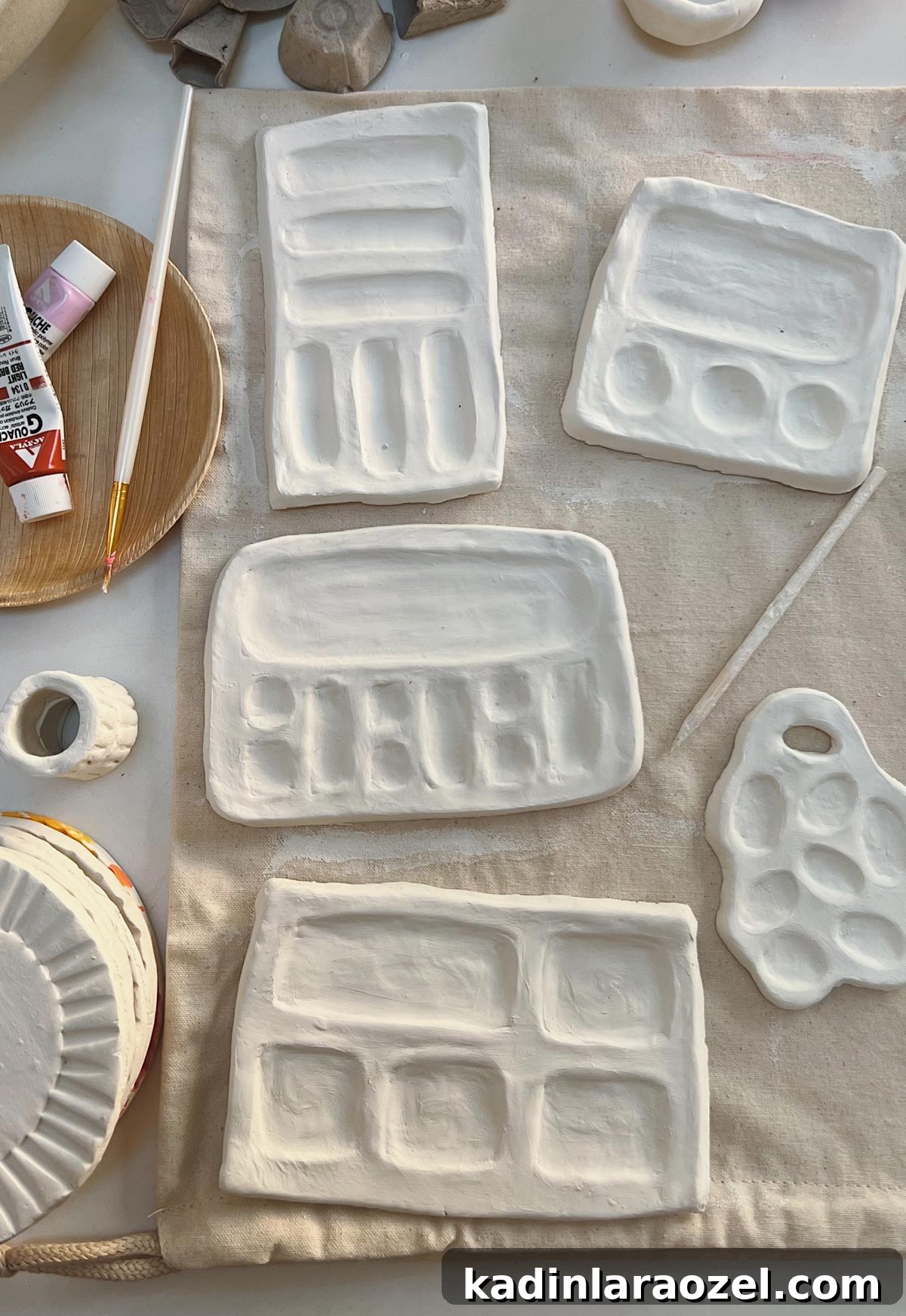 handmade paint palettes made of white, air dry clay, waiting to dry on a table