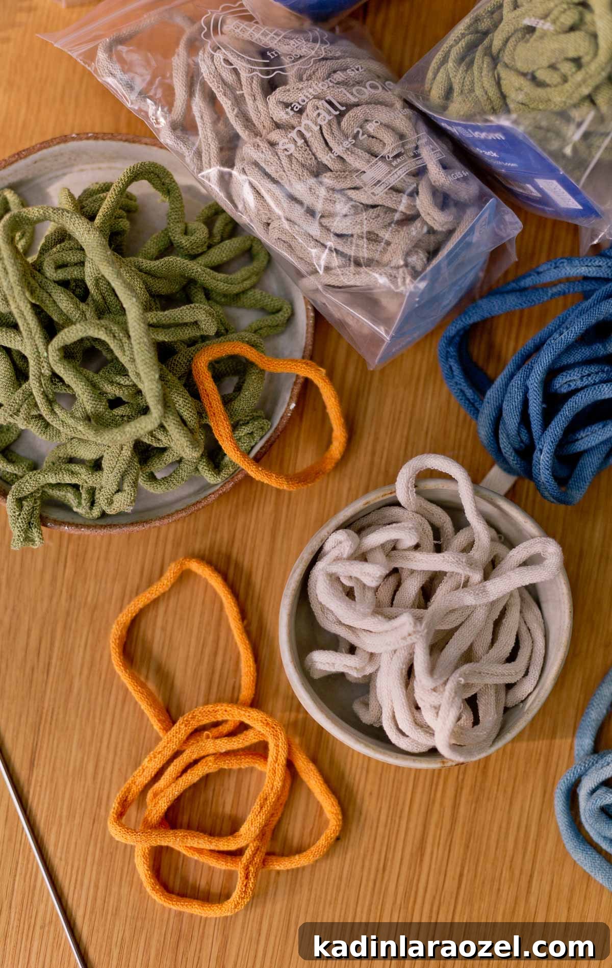 Potholder Loom Weaving: DIY Projects and Techniques 6 potholder loops in various colors, laid out on a wood table