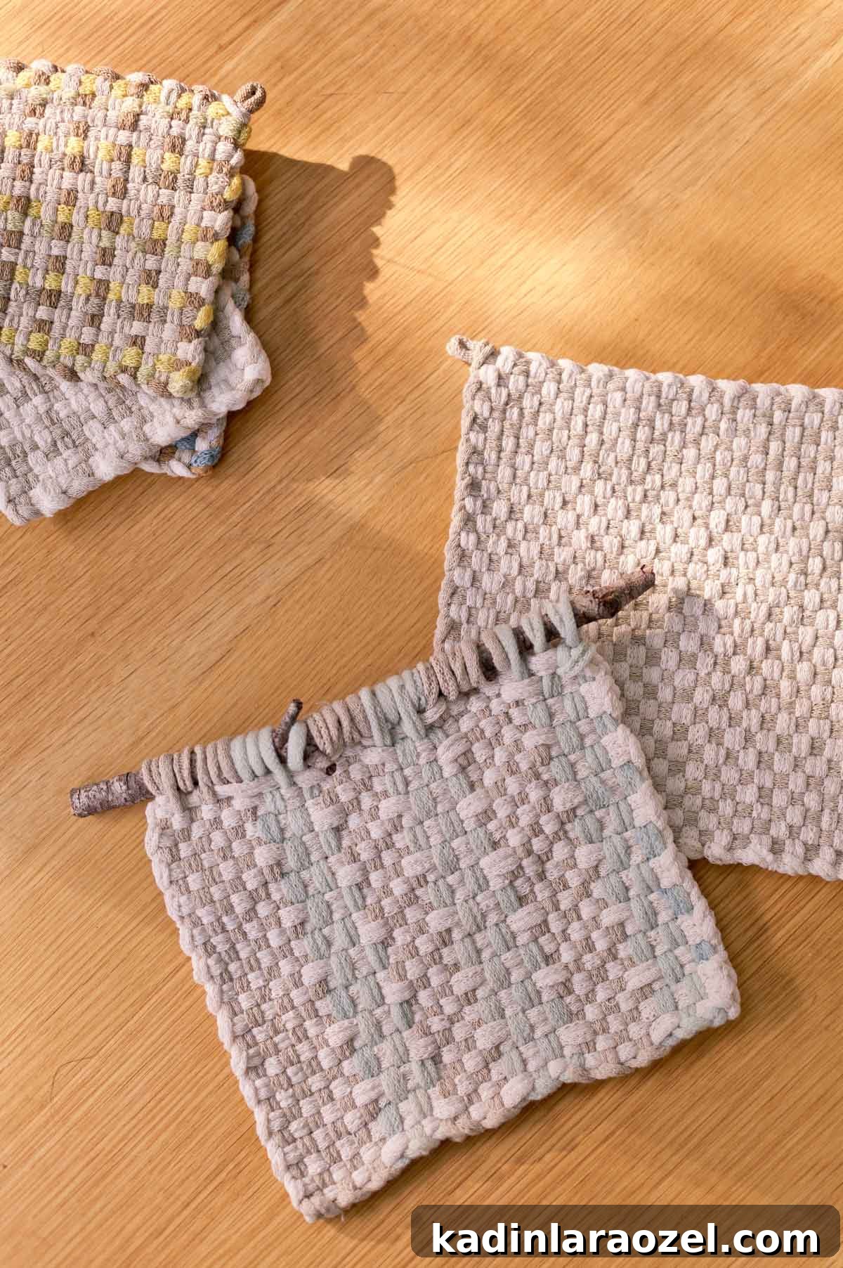 Potholder Loom Weaving: DIY Projects and Techniques 9 neutral weavings laid out on wood table in stacks, after being made with a potholder loom