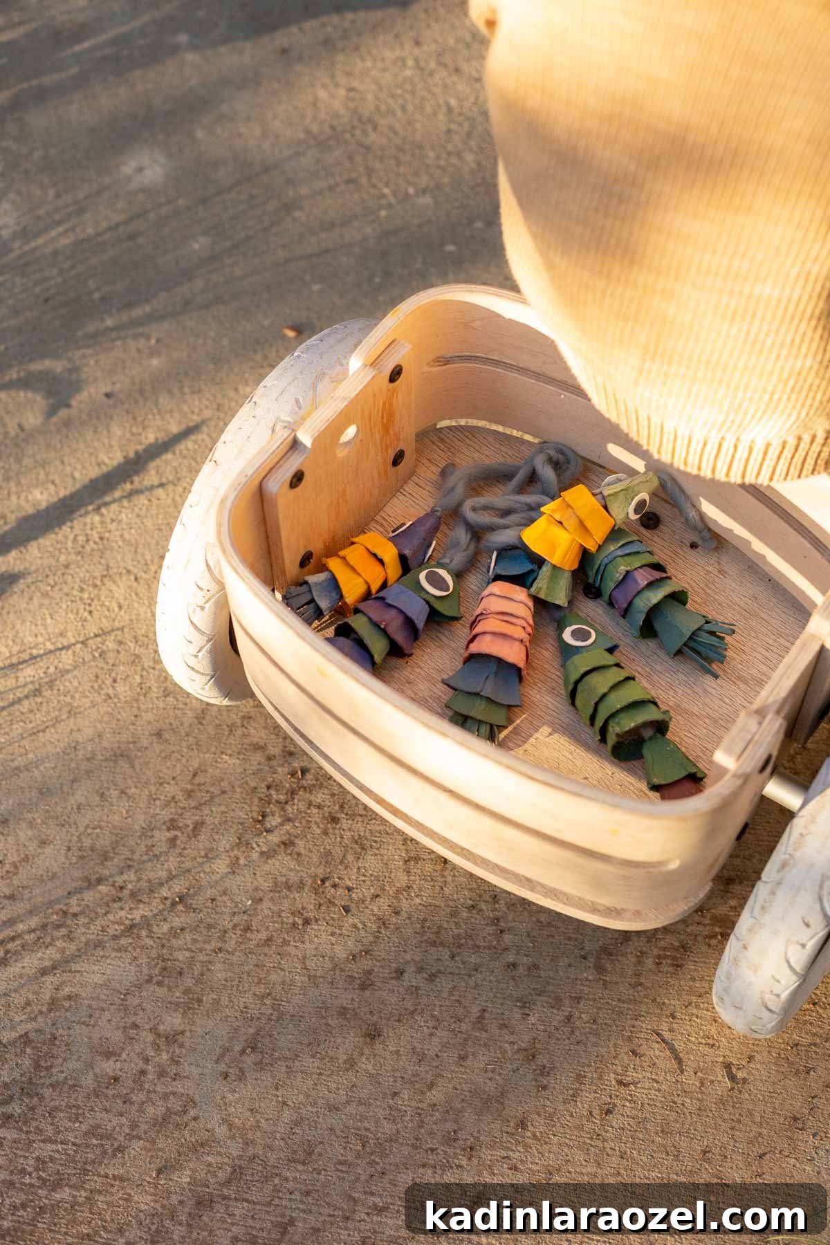 DIY Egg Carton Fish Craft: Make Colorful Fish from Egg Cartons for Kids 3 Colorful fish made of egg cartons, inside a kid's wood bike basket