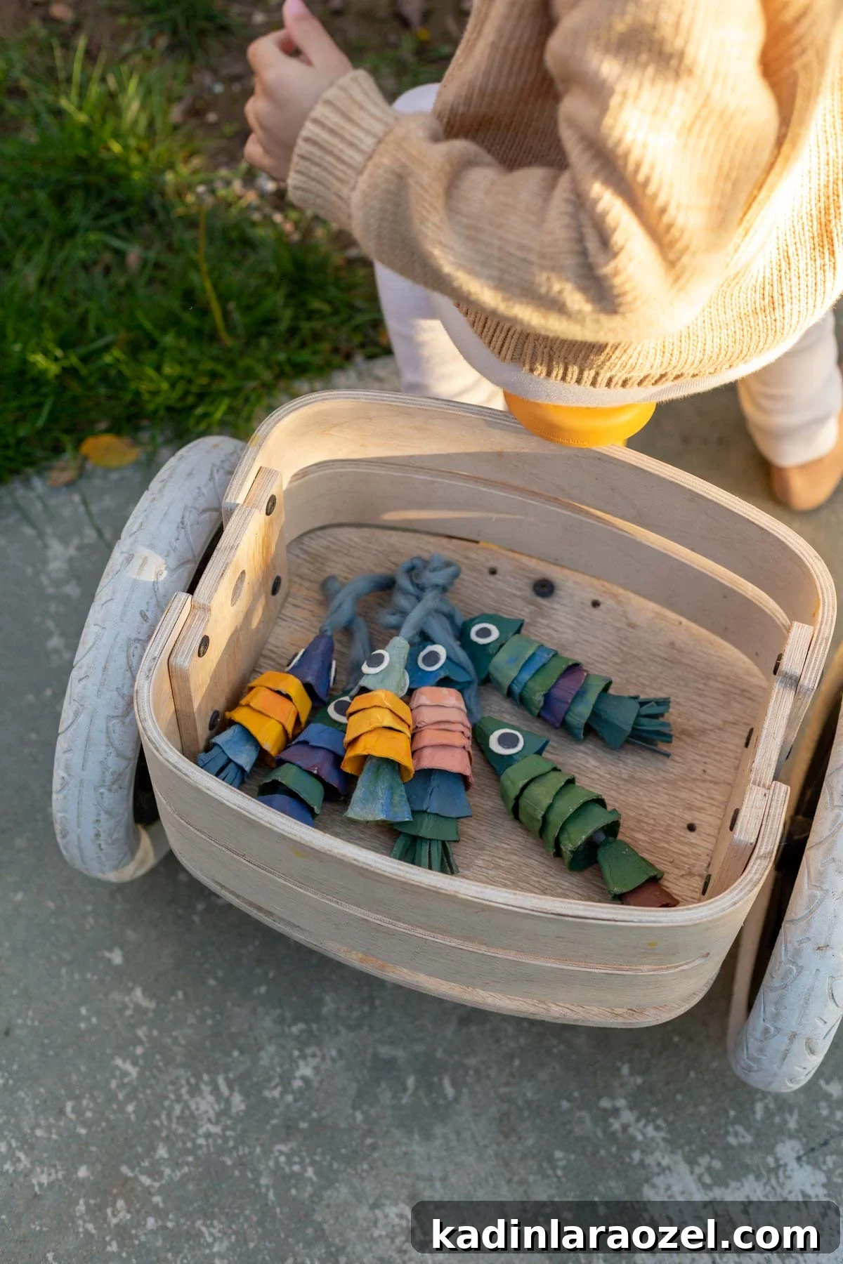 DIY Egg Carton Fish Craft: Make Colorful Fish from Egg Cartons for Kids 7 Colorful craft fish made of egg cartons, in the back of a child's bike basket