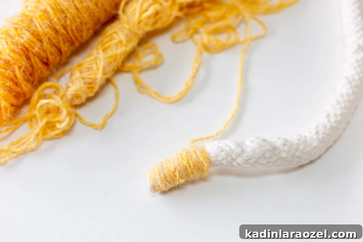 yellow yarn being wrapped around cotton cording over and over again