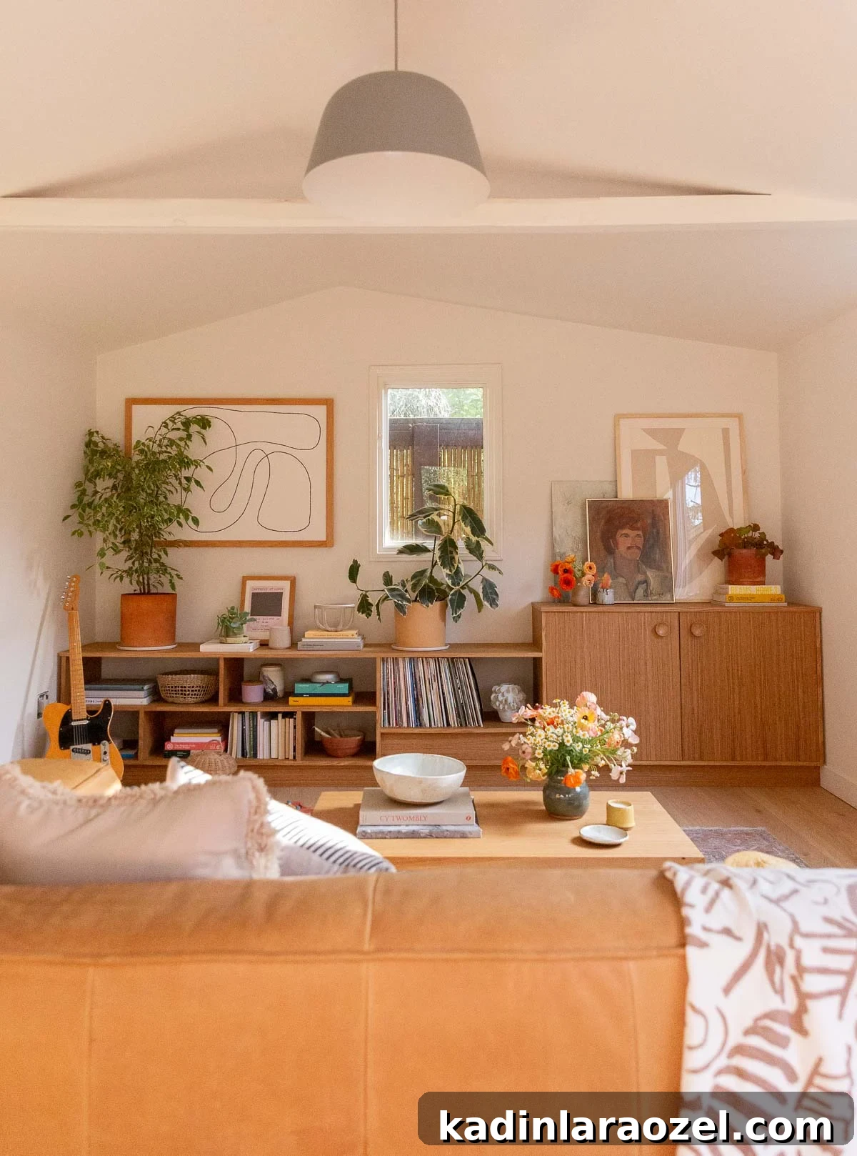 A white room with wall to wall wood built-ins and wood floors in a living space with earthy eclectic accessories